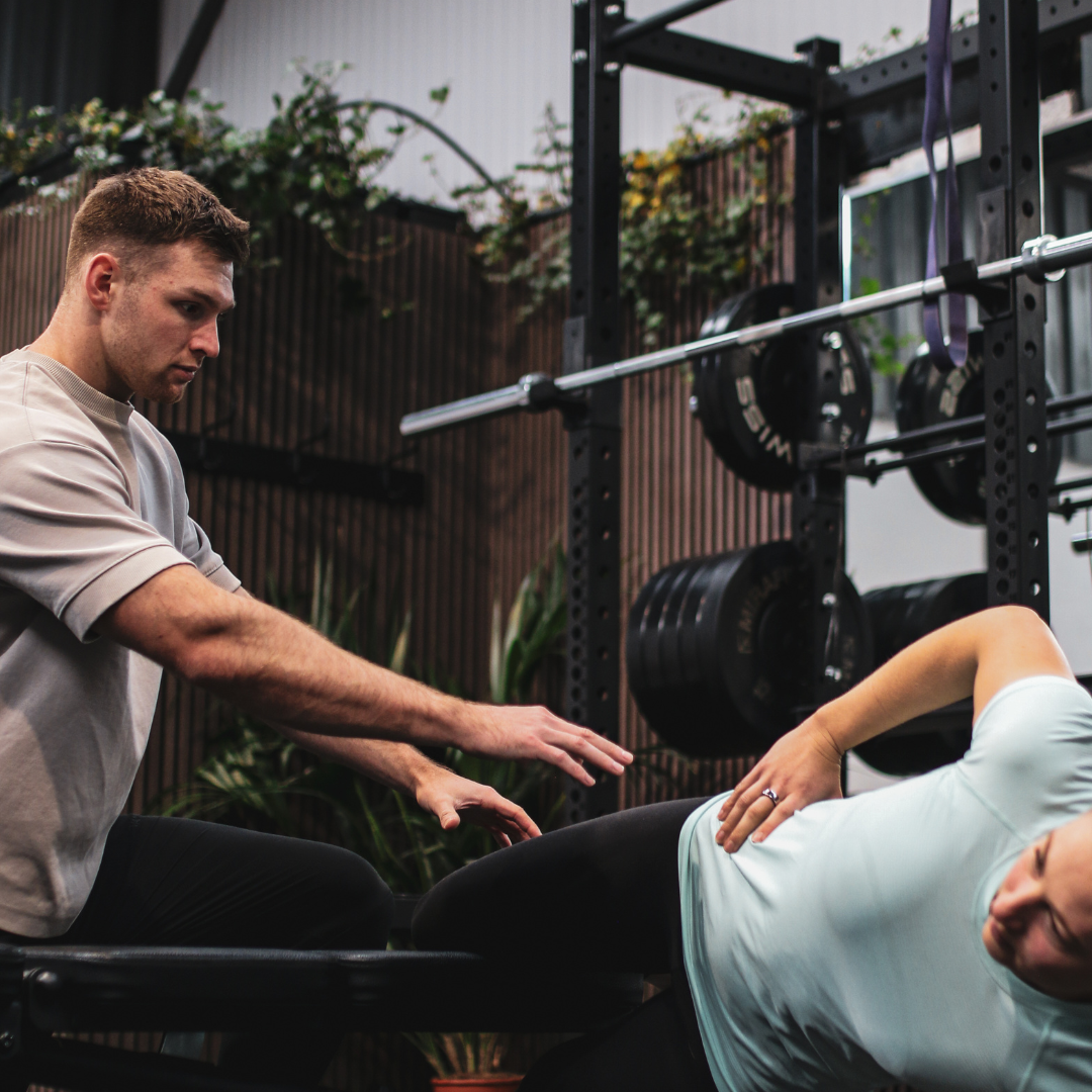 Fin Feaver coaching a client on the strength floor at Proteus